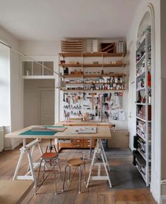 a room with many different types of crafting supplies on the wall and shelves above it