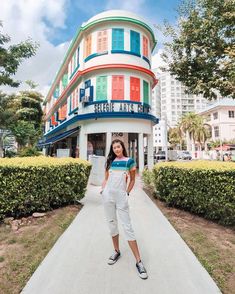 a woman standing in front of a multi - colored building