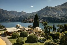 an aerial view of a resort with mountains in the background and trees on the lawn