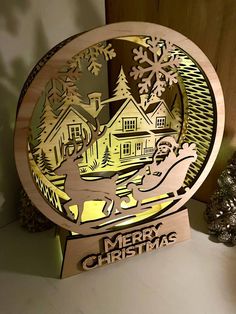 a merry christmas ornament on a shelf next to a tree and snowflakes