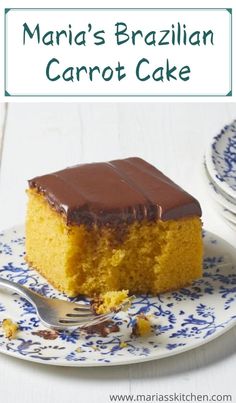 a piece of cake with chocolate frosting on a blue and white plate next to a fork