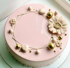 a pink cake with gold decorations on it