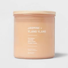 a jar of jaminee and ylang - ylang candle on a white background