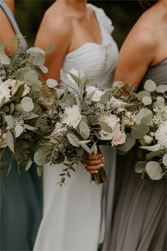 the bridesmaids are holding their bouquets with greenery and flowers on them