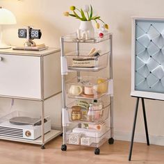 a white dresser sitting next to a tv on top of a hard wood floor