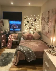 a bedroom decorated in pink and grey with lights on the wall