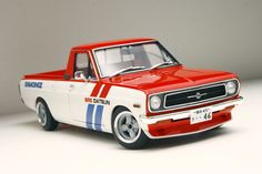 a red and white model truck on a white surface