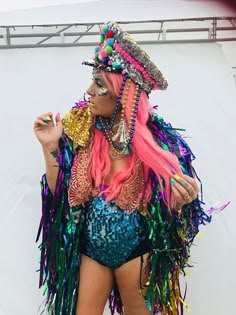 a woman with long pink hair wearing a colorful costume