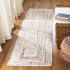 a white rug on the floor next to a basket with books and a book in it