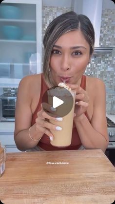 a woman holding a drink in front of her face