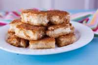 a stack of tofu on a white plate sitting on top of a blue table