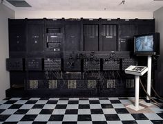 a room with many electrical equipment and a tv on the wall in front of it