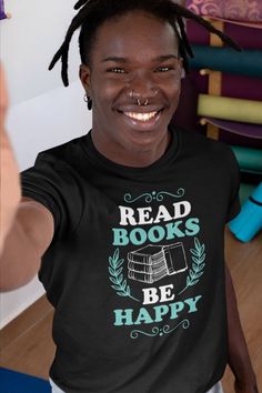 a man with dreadlocks is smiling and wearing a black shirt that reads read books be happy