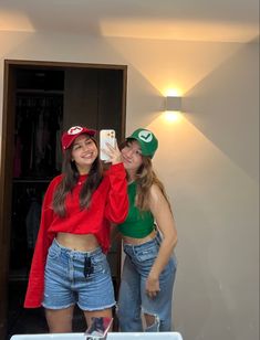 two young women standing next to each other in front of a mirror with their hats on