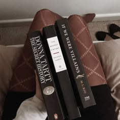 two books sitting on top of each other in front of a person's legs