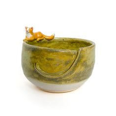 a ceramic bowl with a cat sitting in it