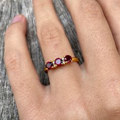 Three gorgeous little faceted garnet gemstones flanked with two tiny diamonds besides the middle one and set in gold vermeil. The open band is adjustable allowing it to be sized up a size. Gold Rings With Rose Cut Diamonds And Garnet, Gold Garnet Ring With Rose Cut Diamonds, Adjustable Elegant Ruby Ring, Gold Ruby Ring With Rose Cut Diamonds For Gift, Gold Ruby Ring With Rose Cut Diamonds As Gift, Fine Jewelry Ruby Ring In Burgundy For Gift, Fine Jewelry Burgundy Ruby Ring Gift, Elegant Red Ruby Toe Ring, Gold Garnet Open Ring