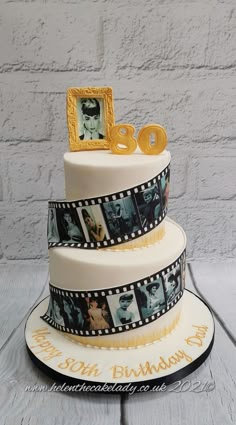 a three tiered cake decorated with film strips and photos