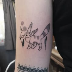 a black and white tattoo of a dog on the left arm with flowers in it