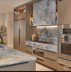 a kitchen with marble counter tops and stainless steel appliances in the middle of the room