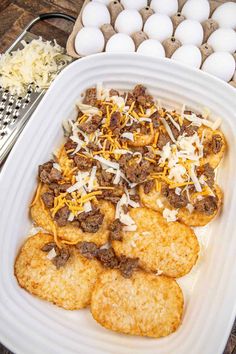 an egg tray with crackers, cheese and meat on it next to some eggs