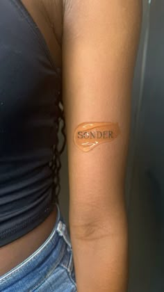 a woman with a tattoo on her arm that reads, sender written in orange