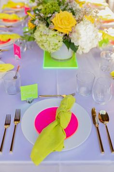 the table is set with silverware and flowers