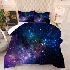 a bed with blue and purple galaxy print on the covers, pillows and pillow cases