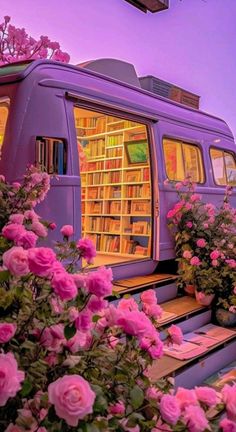 a purple bus is parked next to some pink flowers and bookshelves in the background