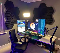 two computer monitors sitting on top of a desk