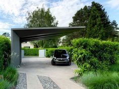 a car is parked under an awning in the driveway