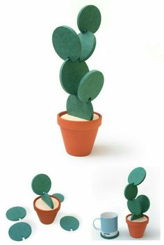 a cactus is sitting in a pot next to some cups