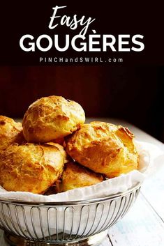 a bowl filled with baked goods sitting on top of a wooden table and text overlay reads easy gougeres