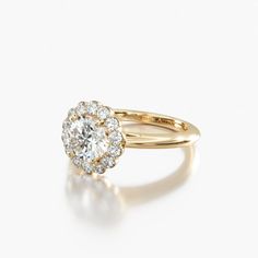 a yellow gold ring with an oval diamond surrounded by smaller round diamonds on the band