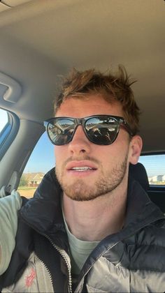 a man wearing sunglasses sitting in the back seat of a car