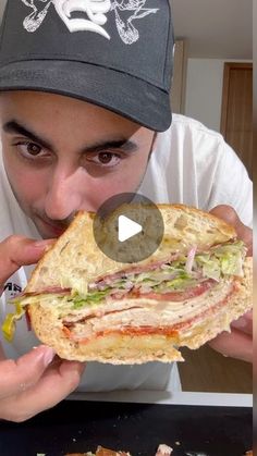 a man eating a large sandwich on top of a pan