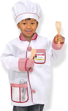 a young boy wearing a chef's outfit and holding a spatula