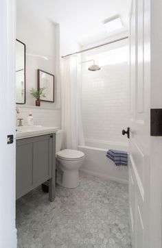 a bathroom with a toilet, sink and mirror