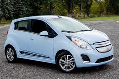 a small blue car parked in a parking lot