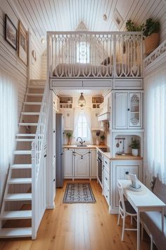 a kitchen with white cabinets and stairs leading up to the second floor