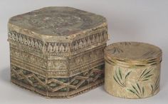 an old wooden box with designs on it next to a small tin container that has been turned into a lid