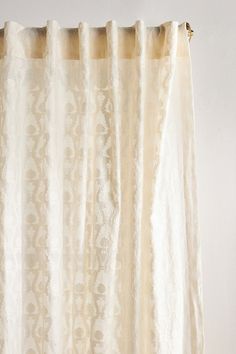 a white curtain hanging on the side of a wall