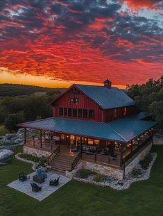 an aerial view of a large house with a red sky in the background at sunset