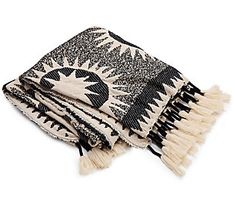 a black and white throw with fringes on it's edges, sitting on a white surface