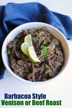 a white bowl filled with shredded meat and garnished with cilantro