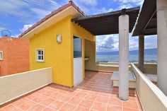 a yellow and orange house sitting on top of a roof