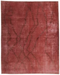 a red rug with an intricate design on the front and back side, in shades of brown