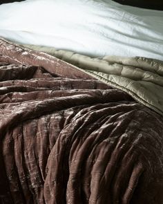 an unmade bed with brown and white sheets