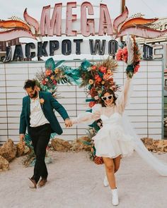 a man and woman dancing in front of a neon sign