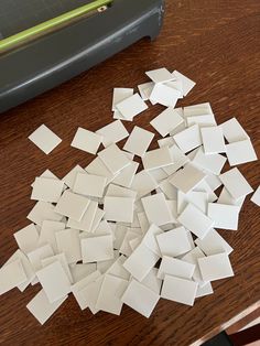 a pile of white tiles sitting on top of a wooden table next to a cutting board